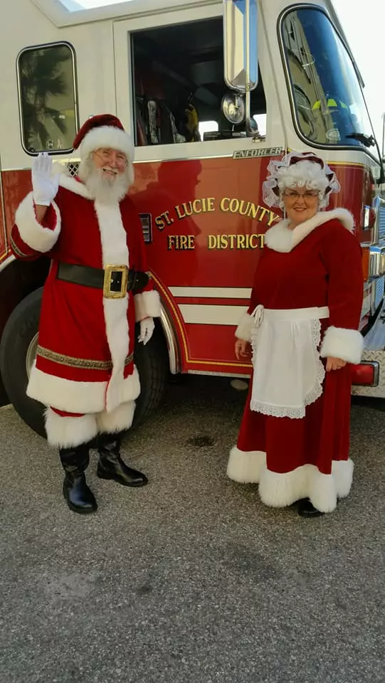 Mr and Mrs Santa Claus Standing Near a Truck
